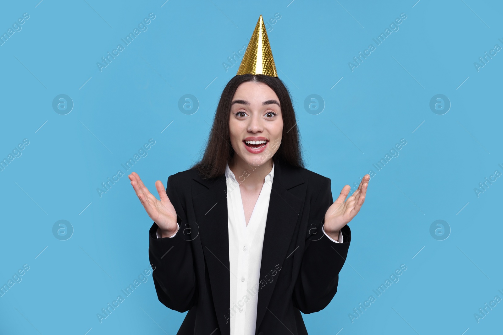 Photo of Happy woman in party hat on light blue background