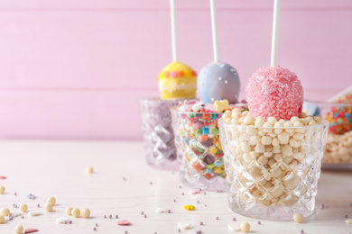 Photo of Egg shaped cake pops on white wooden table, space for text. Easter celebration