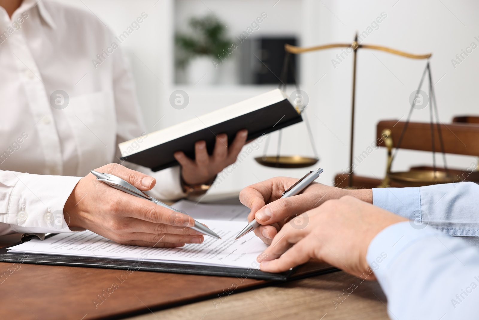 Photo of Lawyers working with documents at wooden table in office, closeup