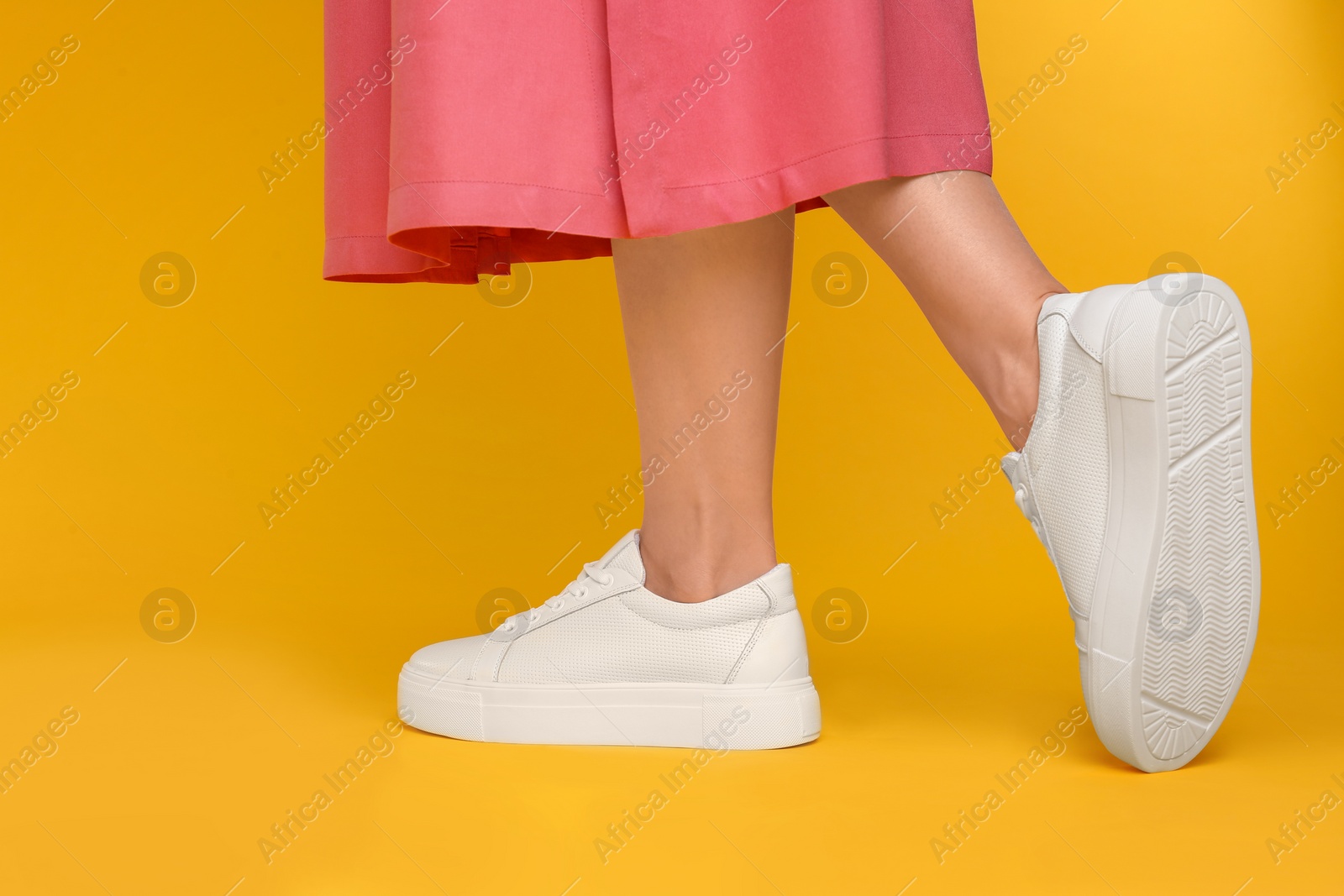 Photo of Woman wearing stylish shoes on yellow background, closeup