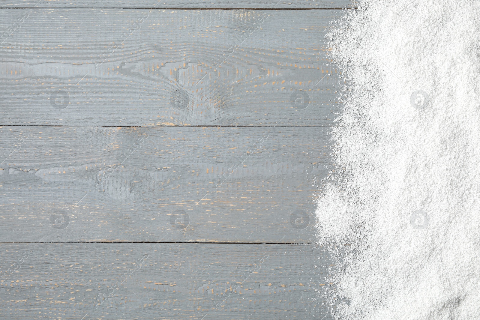 Photo of Artificial snow on light grey wooden background, top view with space for text. Christmas decor