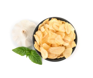 Bowl of dried garlic flakes and basil on white background, top view