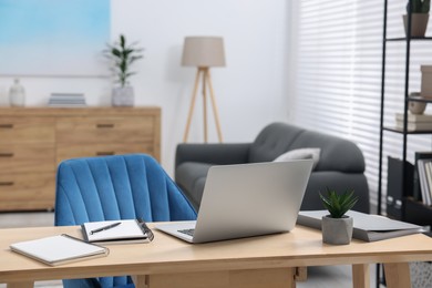 Photo of Home workspace. Laptop and stationery on wooden desk indoors