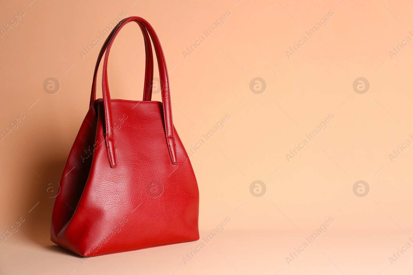 Photo of Stylish woman's bag on pale pink background. Space for text