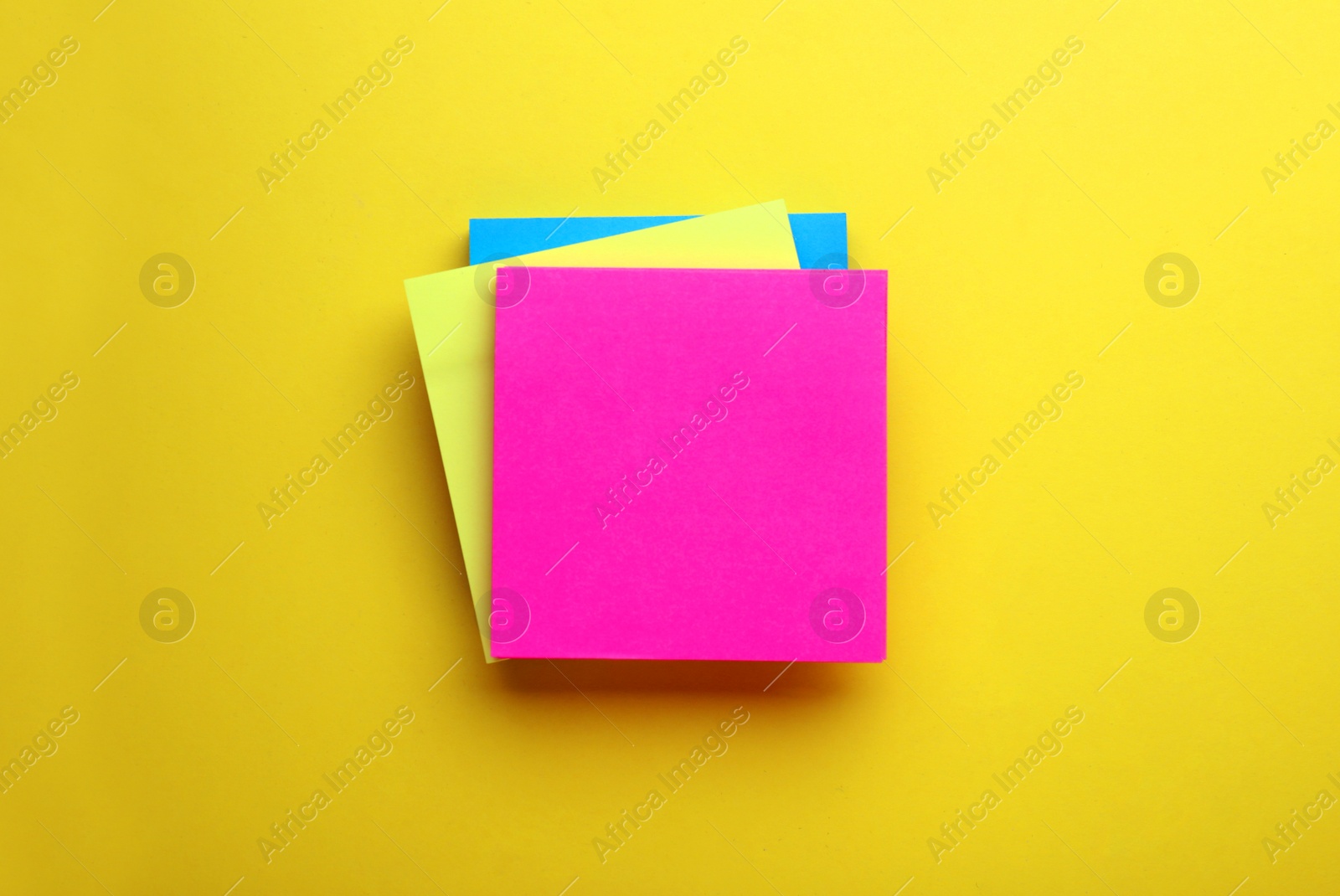 Photo of Paper notes on yellow background, top view