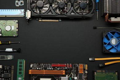 Photo of Frame of graphics card and other computer hardware on black background, flat lay. Space for text