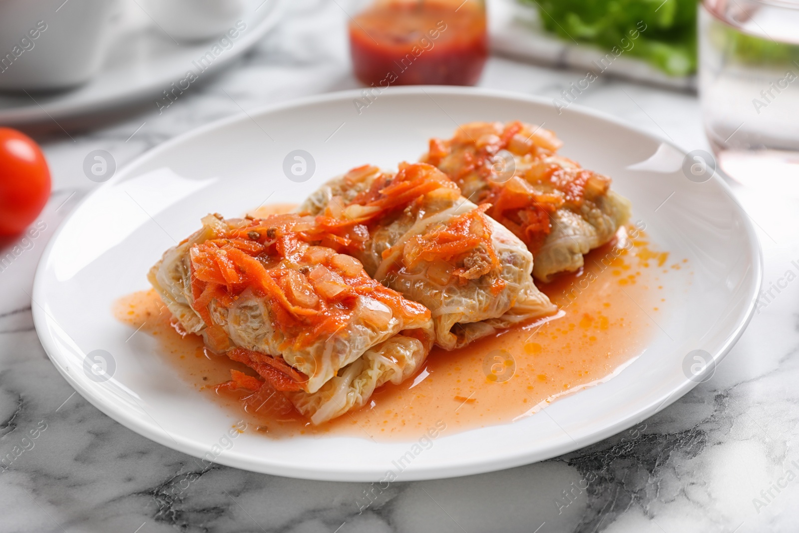 Photo of Delicious cabbage rolls served on white marble table, closeup