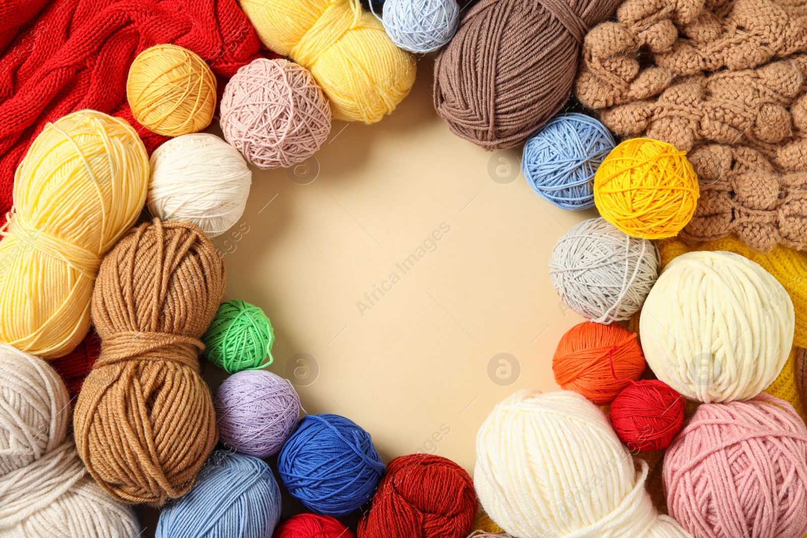 Photo of Frame of colorful woolen yarns on beige background, flat lay. Space for text