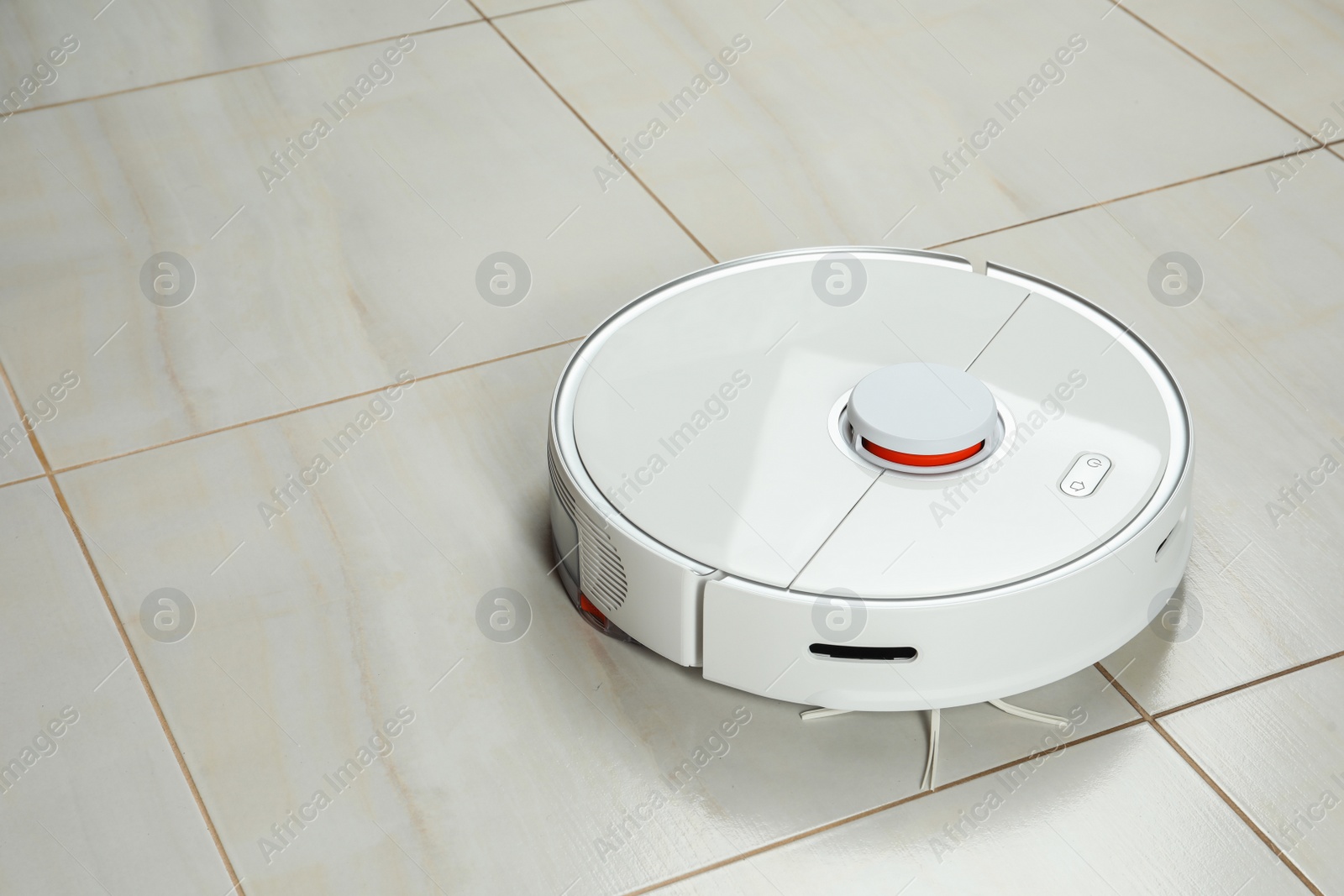 Photo of Robotic vacuum cleaner on white tiled floor, space for text