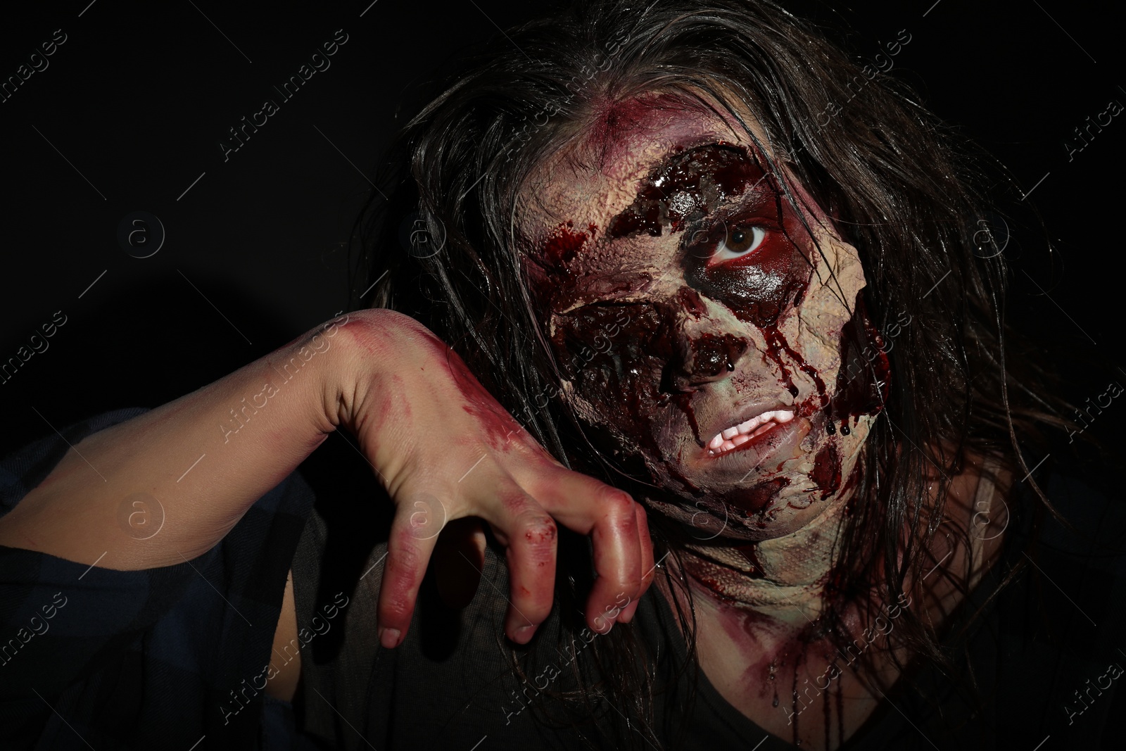 Photo of Scary zombie on dark background, closeup. Halloween monster