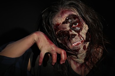 Scary zombie on dark background, closeup. Halloween monster