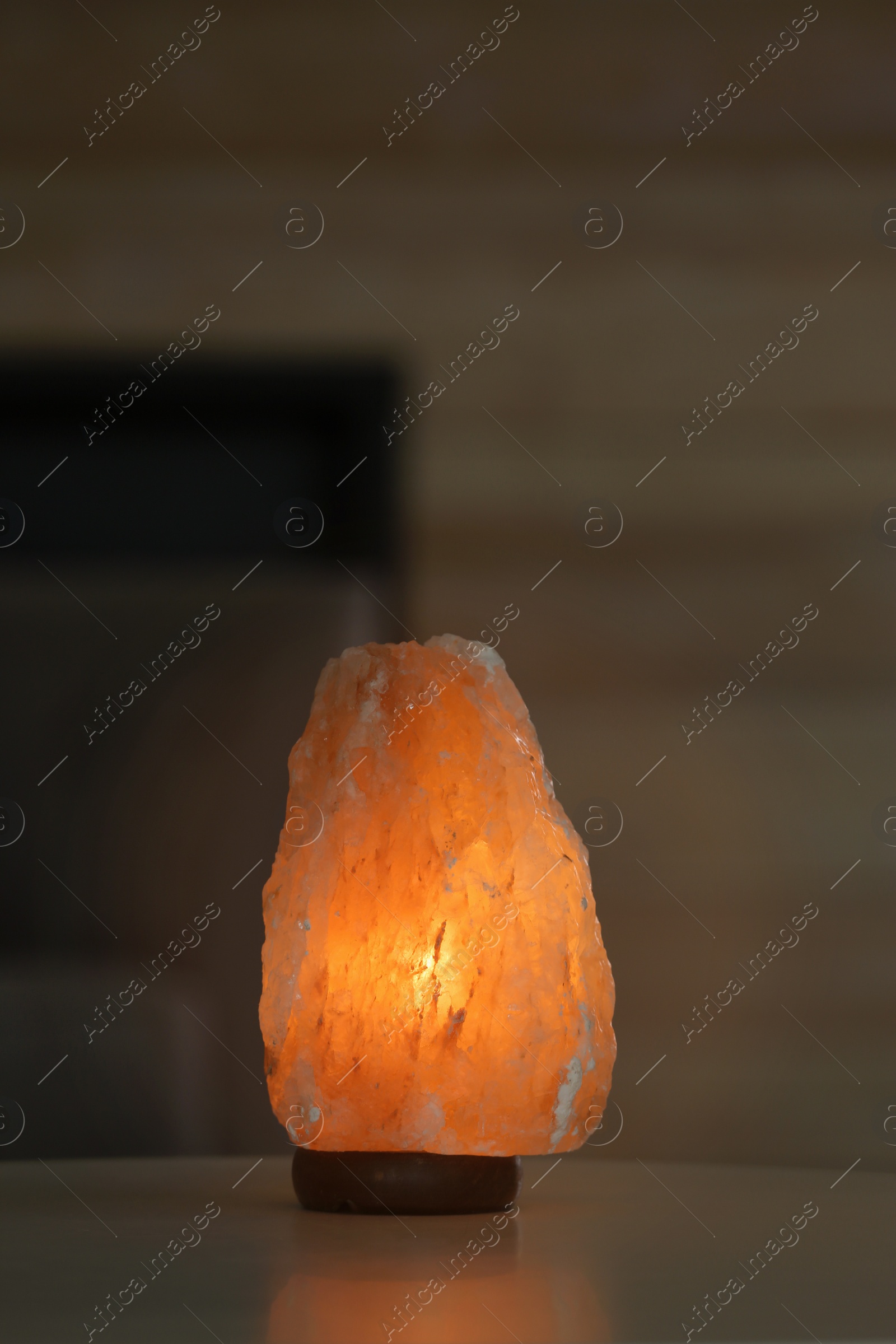 Photo of Himalayan salt lamp on table against blurred background