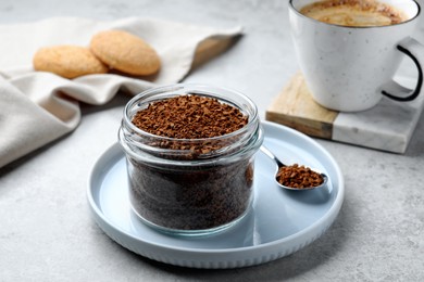 Spoon and glass jar with instant coffee on light table