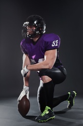 Photo of American football player with ball on dark background