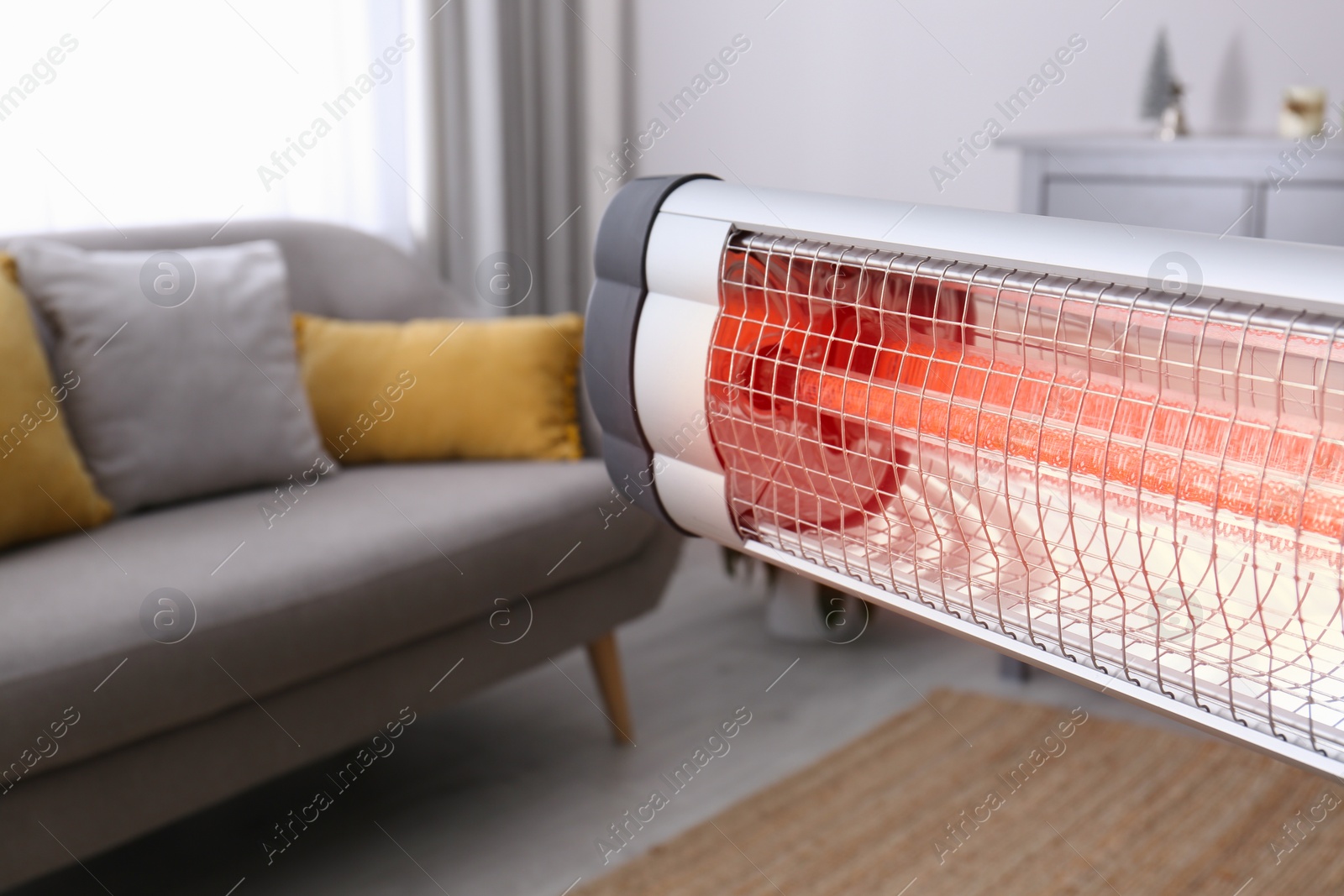 Photo of Modern electric infrared heater in room, closeup. Space for text