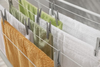 Photo of Clean terry towels hanging on drying rack, closeup