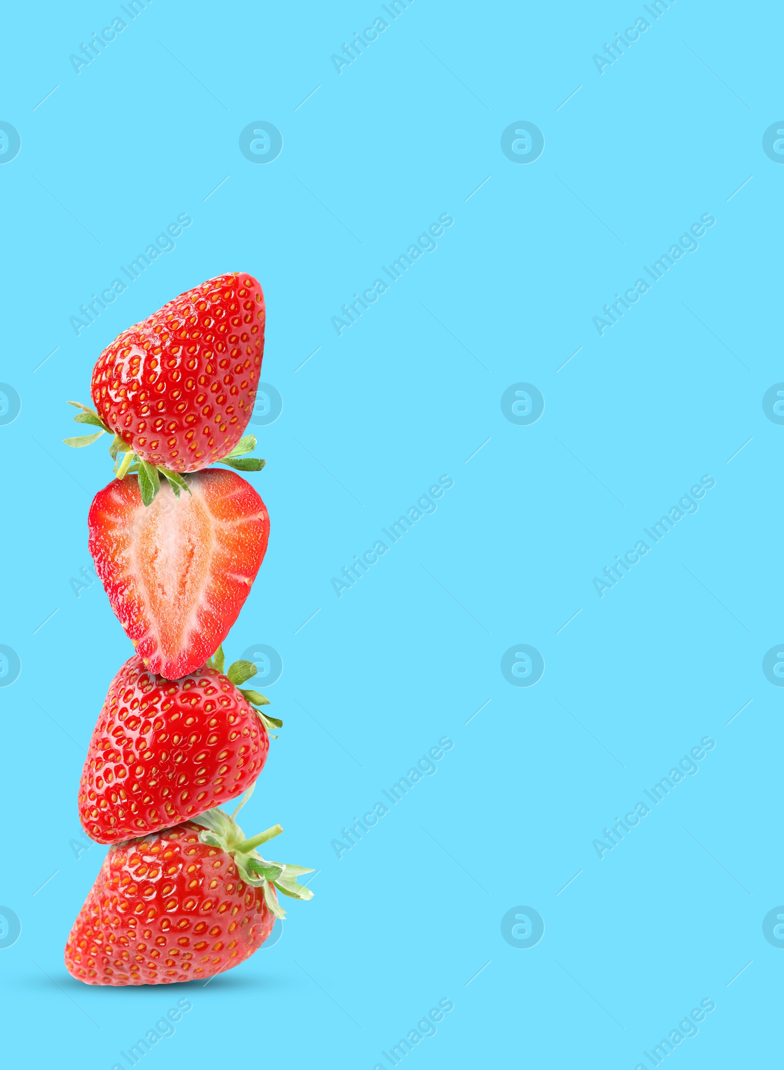 Image of Stack of fresh strawberries on light blue background, space for text