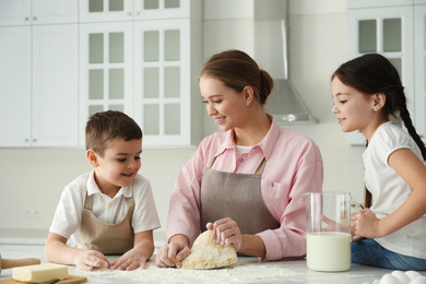 Photo of Happy family cooking together in kitchen at home