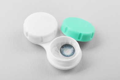 Photo of Case with blue contact lenses on light grey background