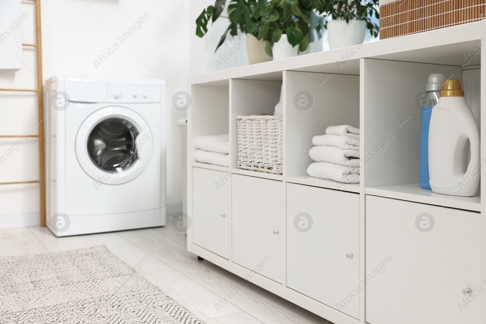 Photo of Laundry room interior with washing machine and furniture