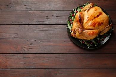 Delicious cooked turkey served on wooden table, top view with space for text. Thanksgiving Day celebration