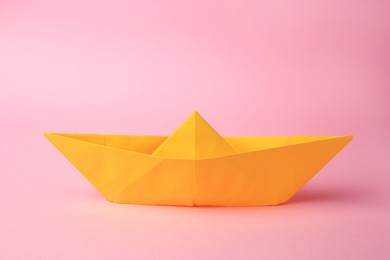 Origami art. Paper boat on pink background