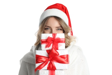Beautiful young woman in Santa hat with Christmas presents on white background