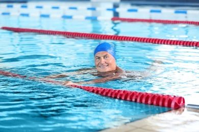 Photo of Sportive senior man in indoor swimming pool