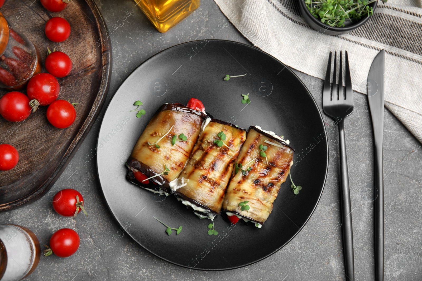 Photo of Delicious baked eggplant rolls served on grey table, flat lay