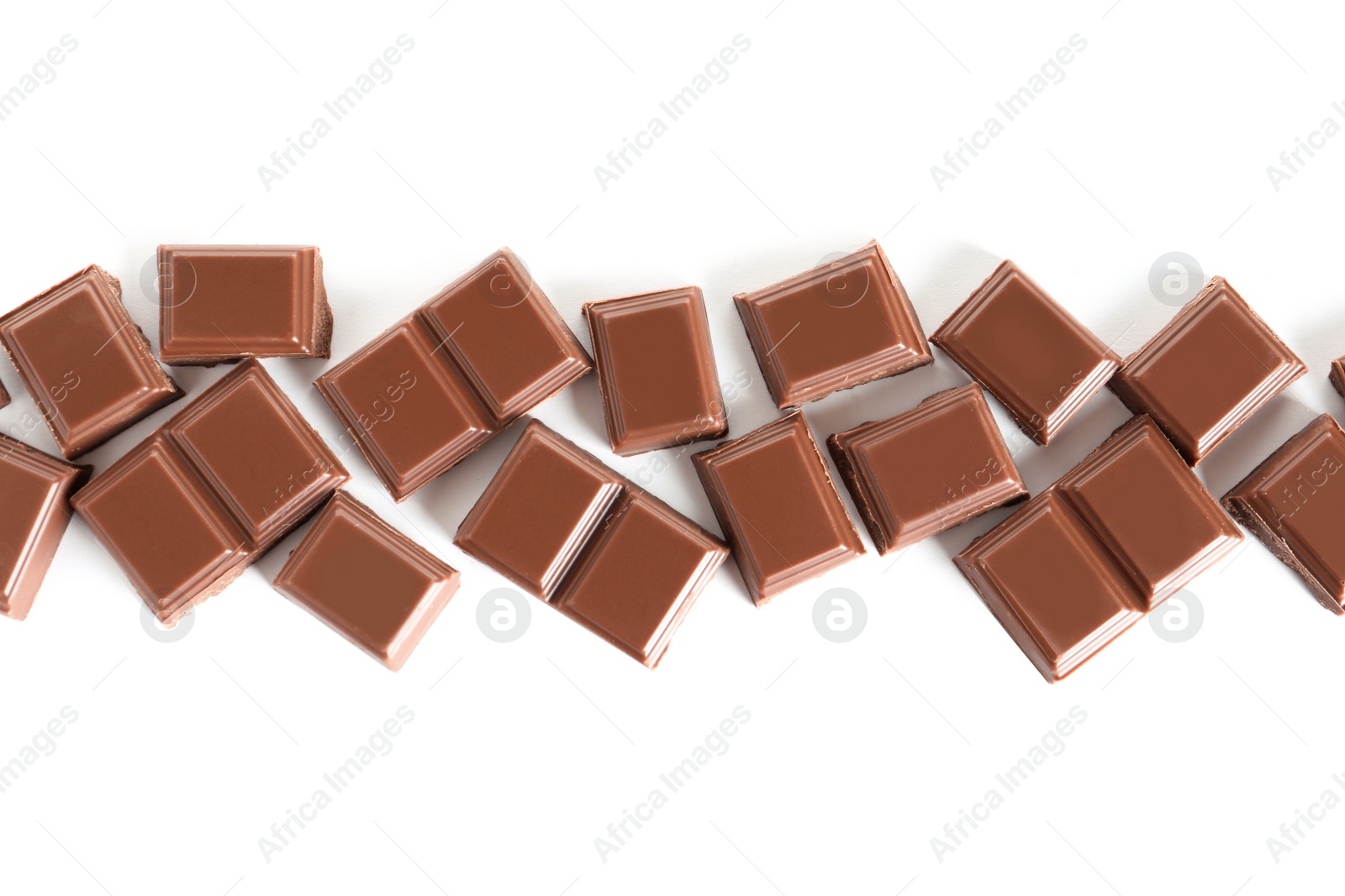 Photo of Pieces of tasty milk chocolate on white background, top view