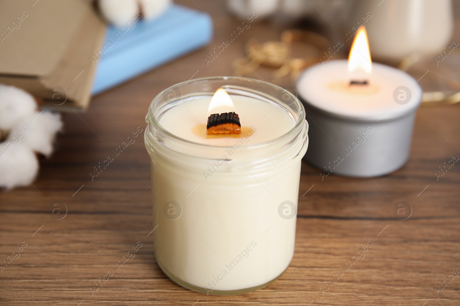 Photo of Burning candle with wooden wick on table