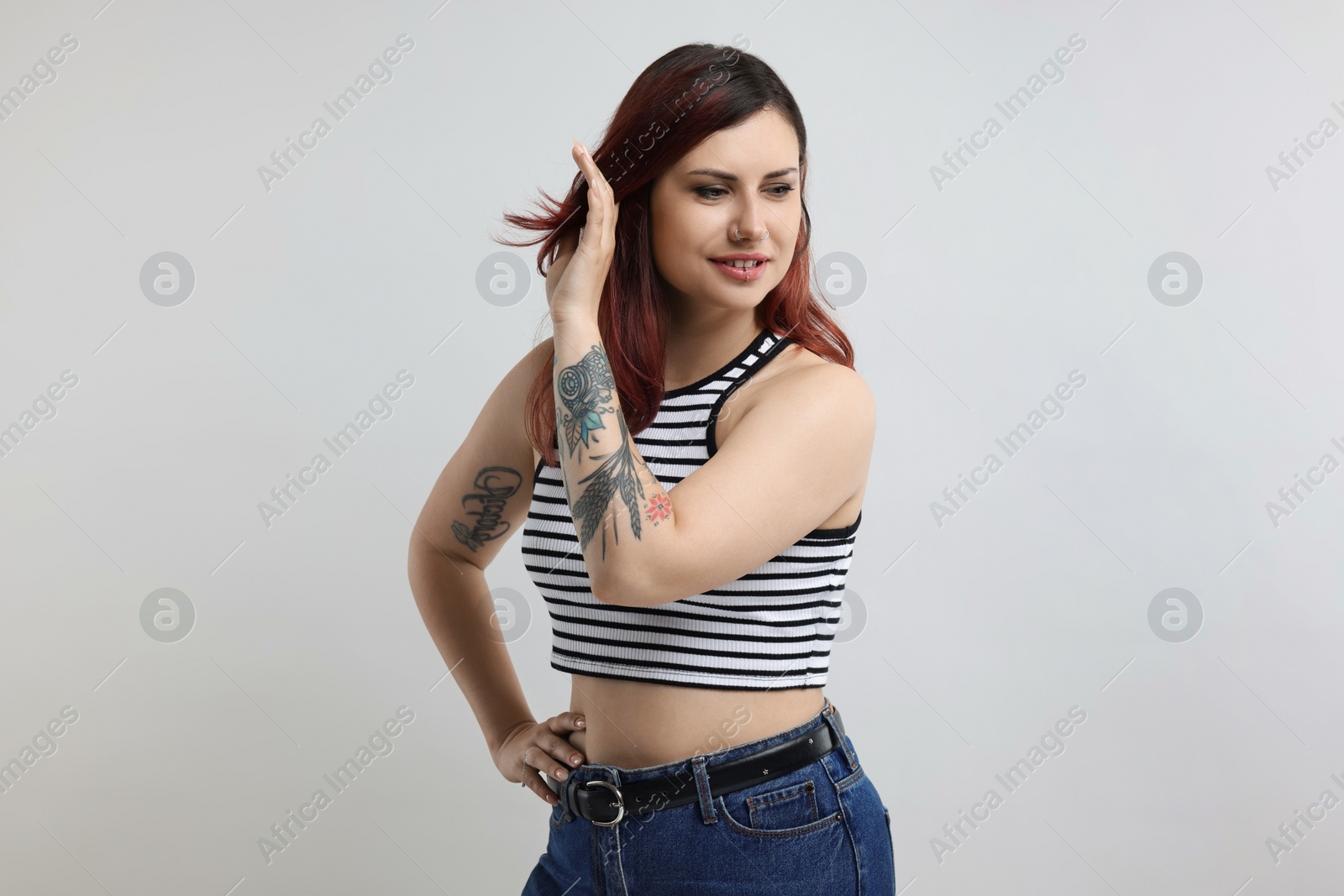 Photo of Portrait of beautiful tattooed woman on gray background