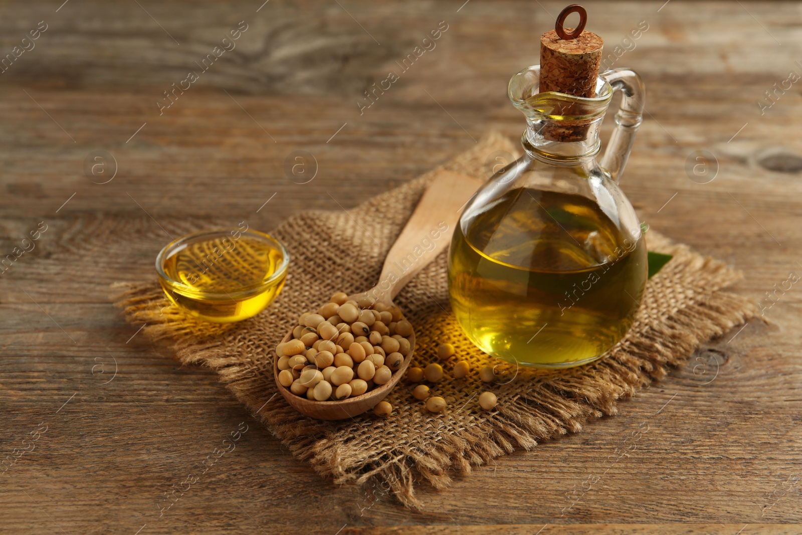 Photo of Composition with soybean oil on wooden table