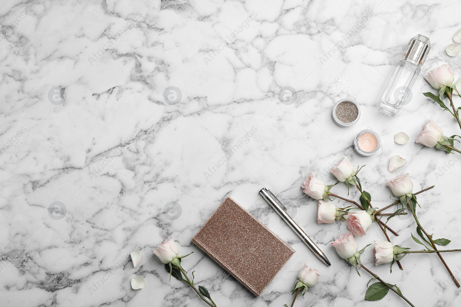 Photo of Flat lay composition with beautiful roses and cosmetics on marble background. Space for text