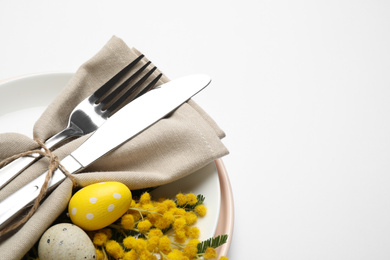 Festive Easter table setting with floral decor on white background, above view