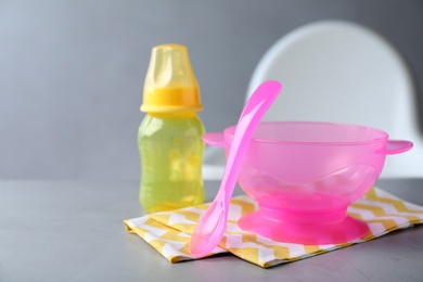 Set of plastic dishware on grey table. Serving baby food