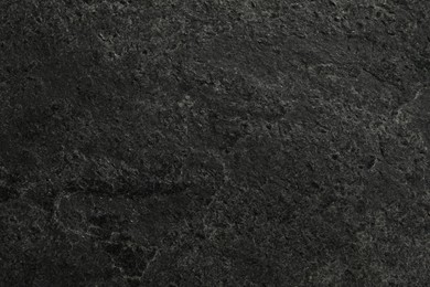 Photo of Texture of dark grey stone surface as background, closeup