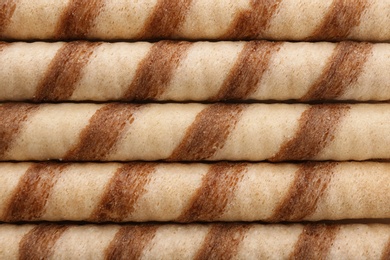 Tasty wafer roll sticks as background, top view. Crispy food