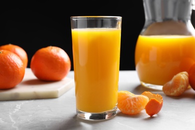 Photo of Glass of fresh tangerine juice and fruits on light table