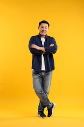 Full length portrait of happy man on yellow background