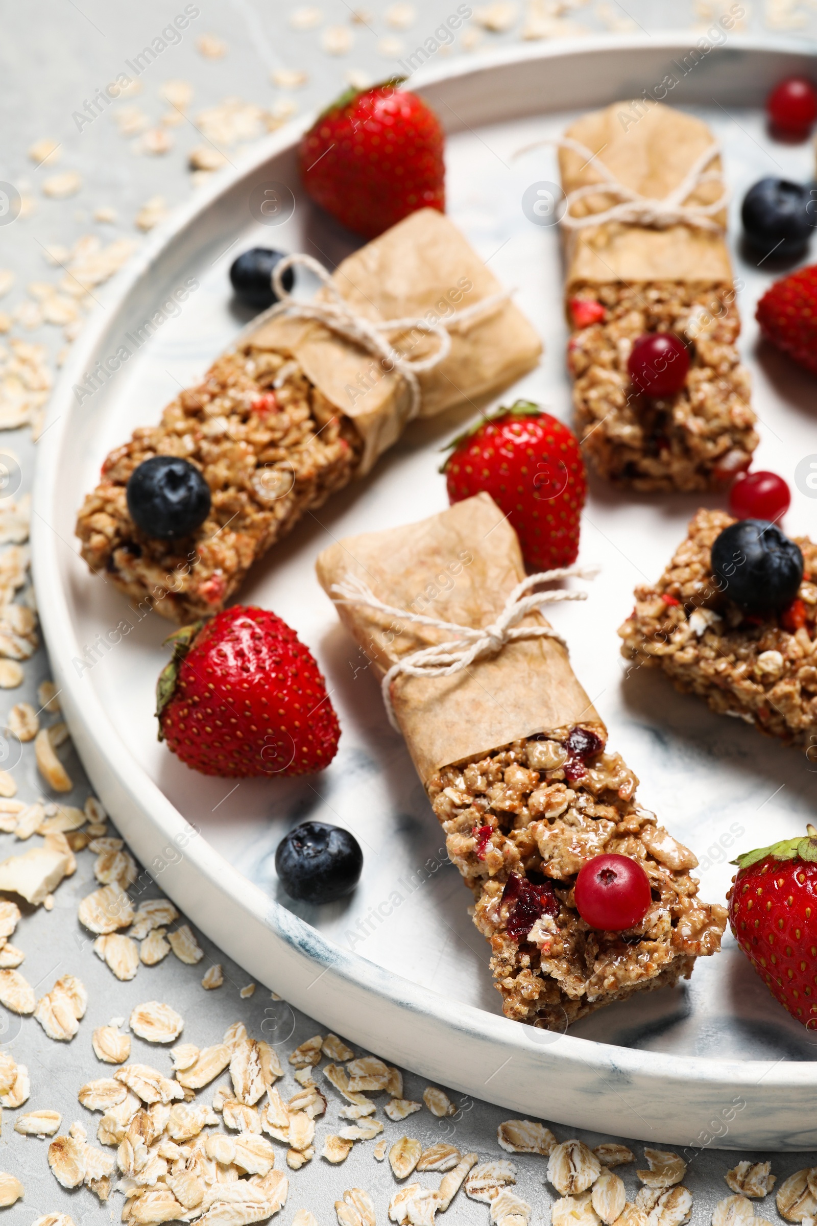 Photo of Tasty granola bars and ingredients on light table