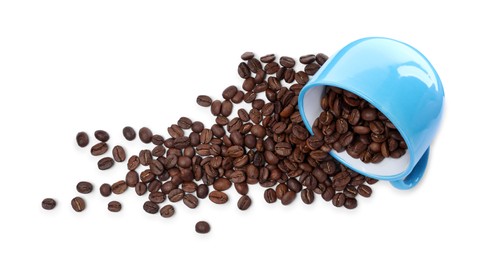Photo of Overturned cup with roasted coffee beans on white background, top view