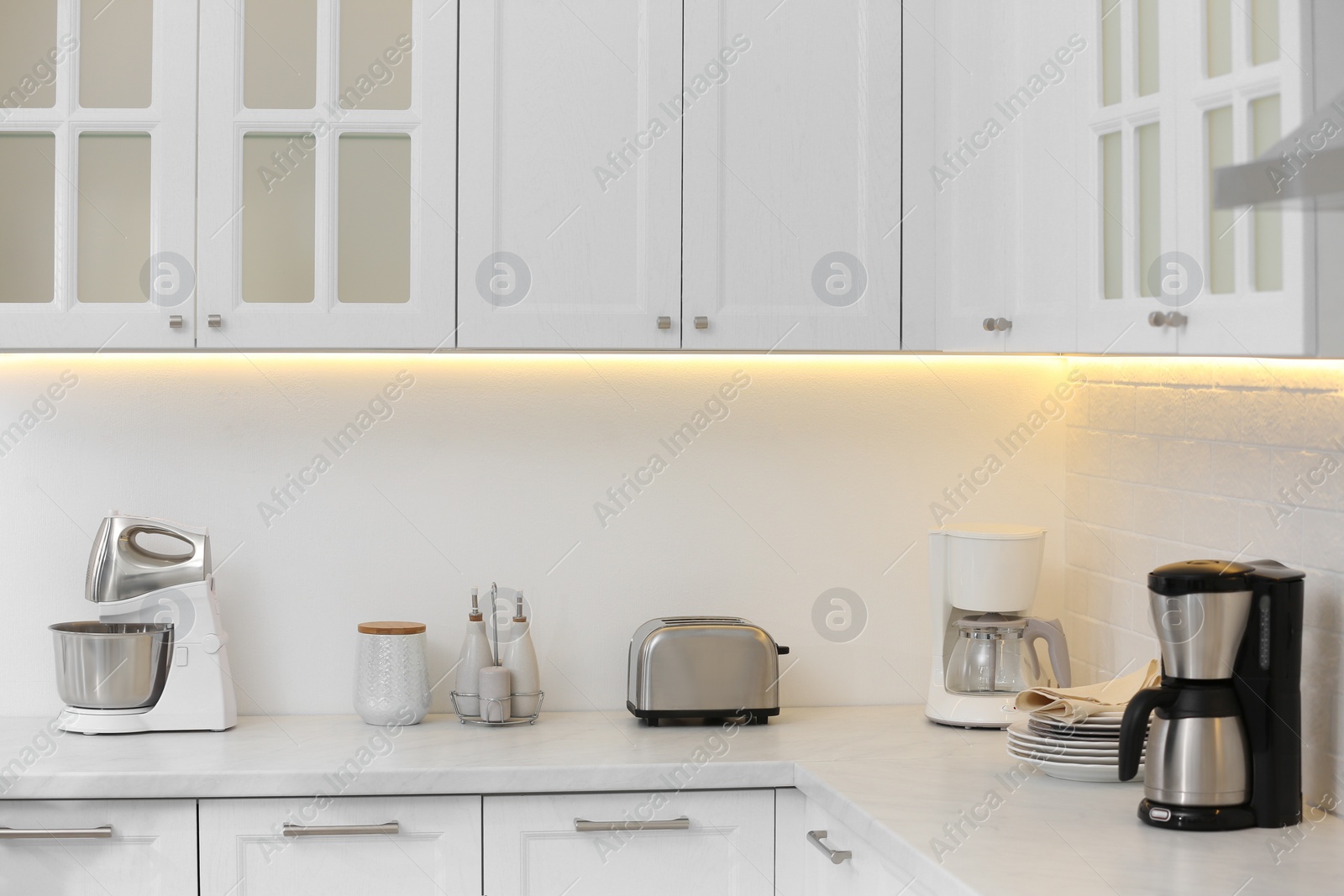 Photo of Modern toaster and other cooking appliances on countertop in kitchen