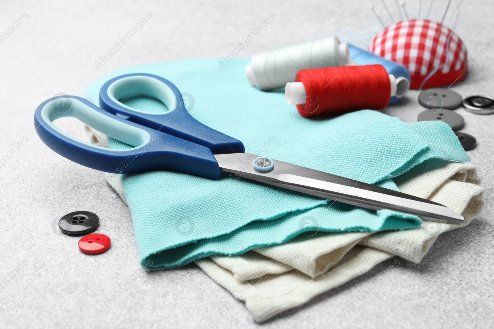 Photo of Scissors, spools of threads and sewing tools on white background