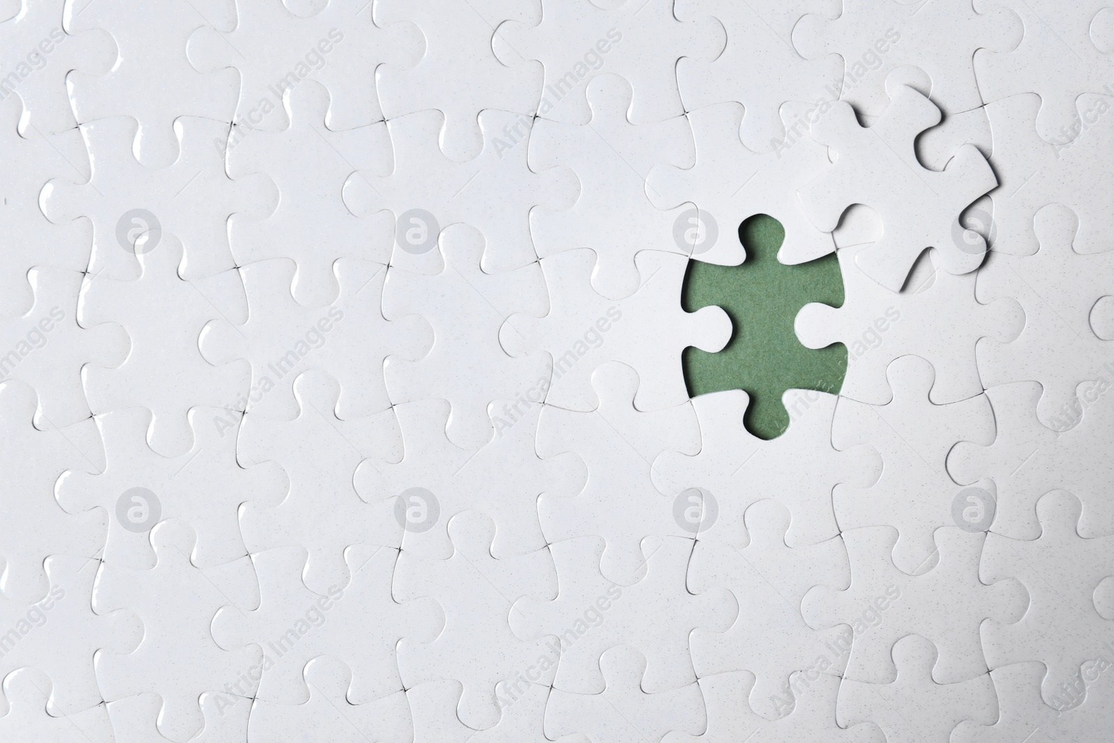 Photo of Blank white puzzle with separated piece on grey background, top view. Space for text