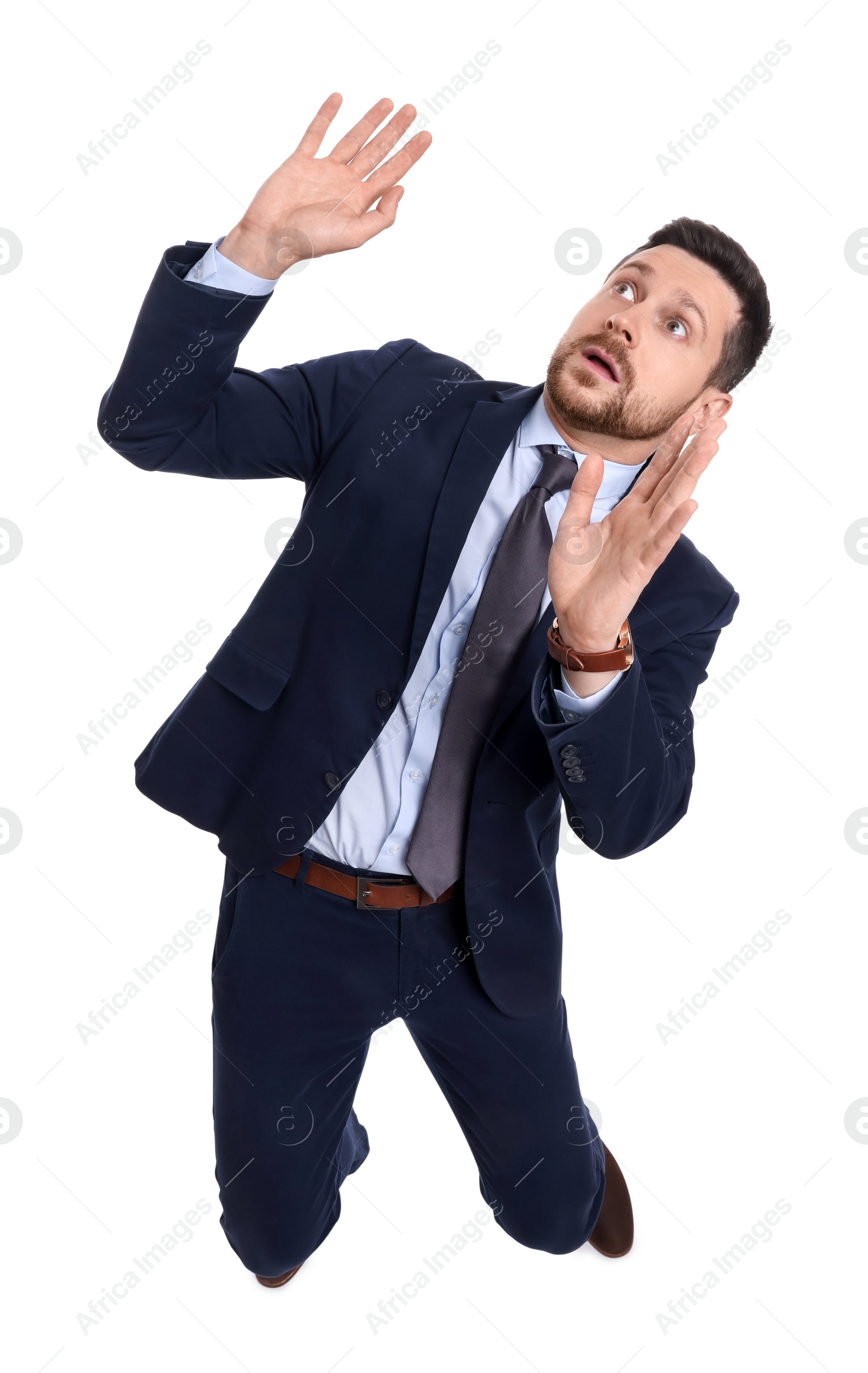 Photo of Handsome bearded businessman in suit avoiding something on white background, above view