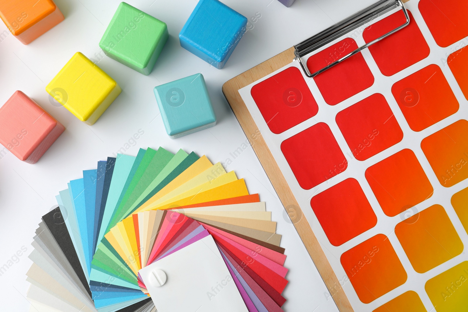 Photo of Color palettes and cubes on white background, top view