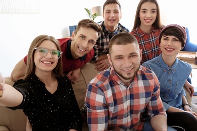 Photo of Happy friends taking selfie indoors