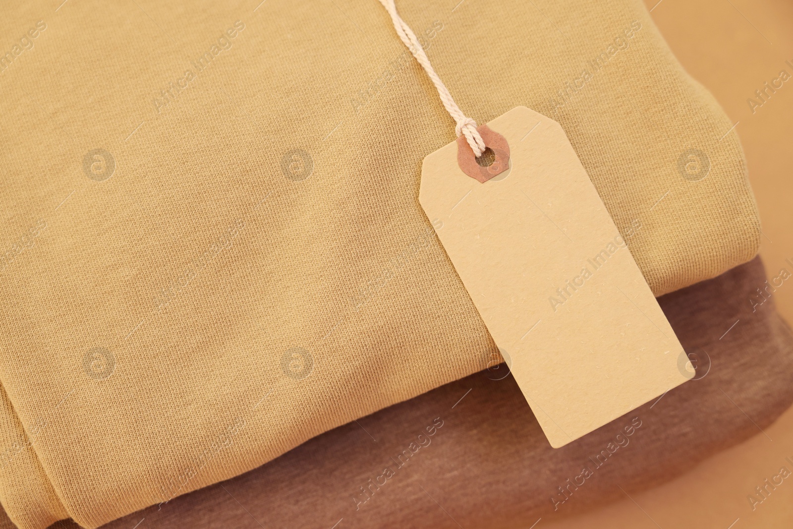 Photo of Garment with cardboard tag, closeup. Space for text