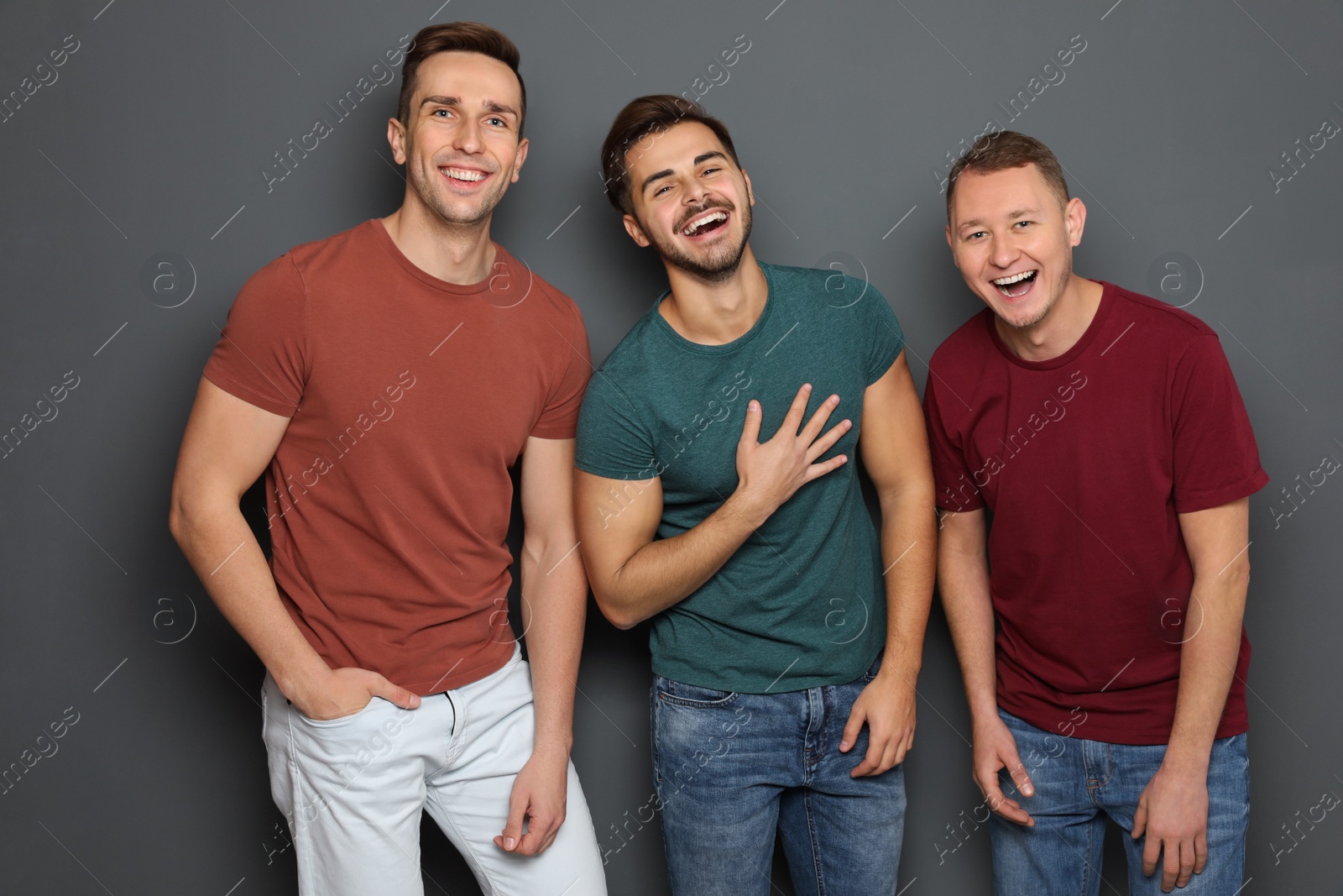 Photo of Group of friends laughing together against gray background